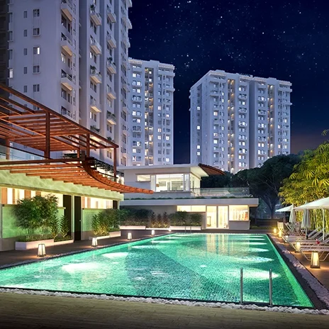 Godrej Hill Retreat swimming pool lit at night beside the clubhouse